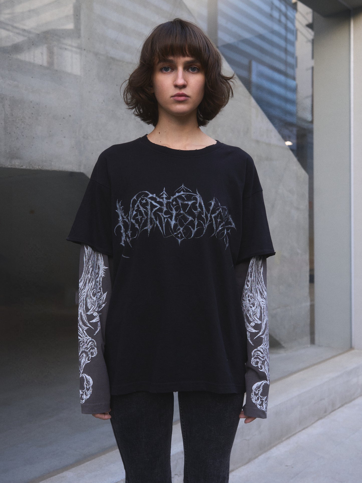 Demonic Heraldry oversized t-shirt — close-up of layered sleeve construction with raw cut outer finish