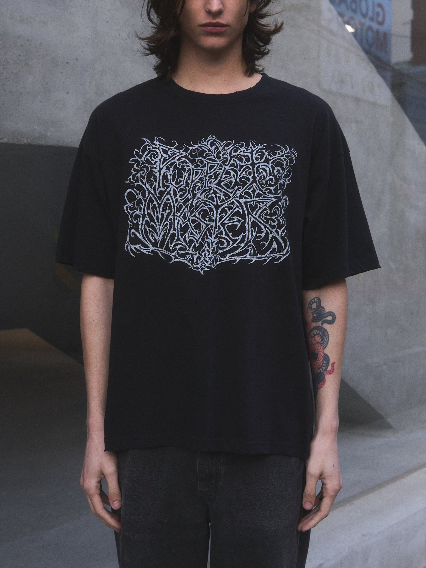 Model wearing Puppet Master oversized t-shirt by Mortisnoir — lifestyle lookbook shot in low light